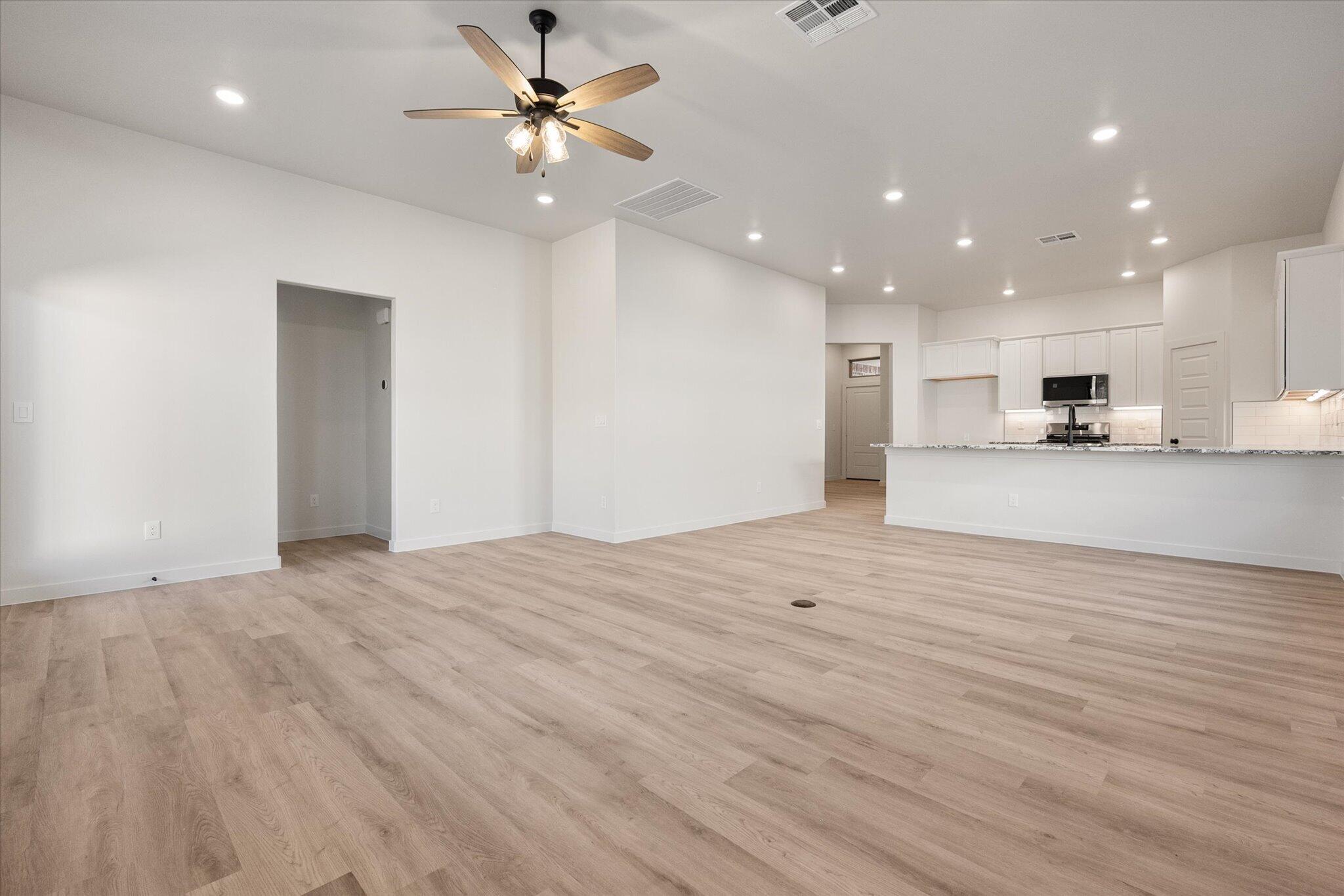 6927 53rd Street Lubbock, TX 79407 - Photo 3 of 21 a view of an empty room and kitchen view with wooden floor