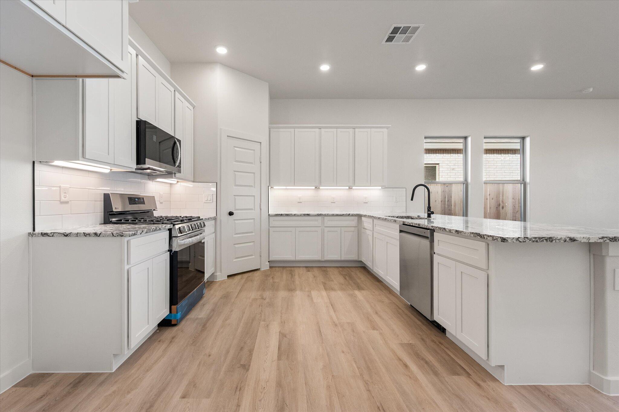 6927 53rd Street Lubbock, TX 79407 - Photo 5 of 21 a kitchen with a sink stainless steel appliances and cabinets