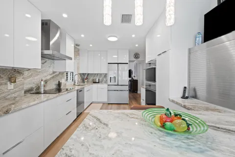 a kitchen with stainless steel appliances granite countertop a sink refrigerator and cabinets