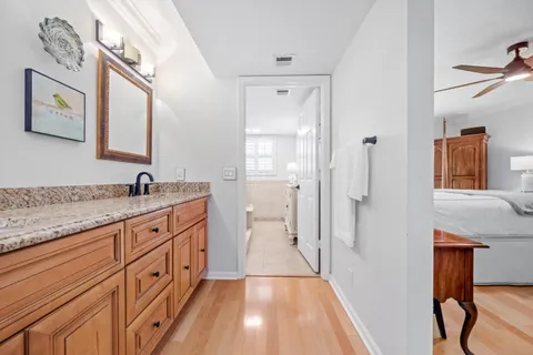 a spacious bathroom with a granite countertop sink a mirror and shower