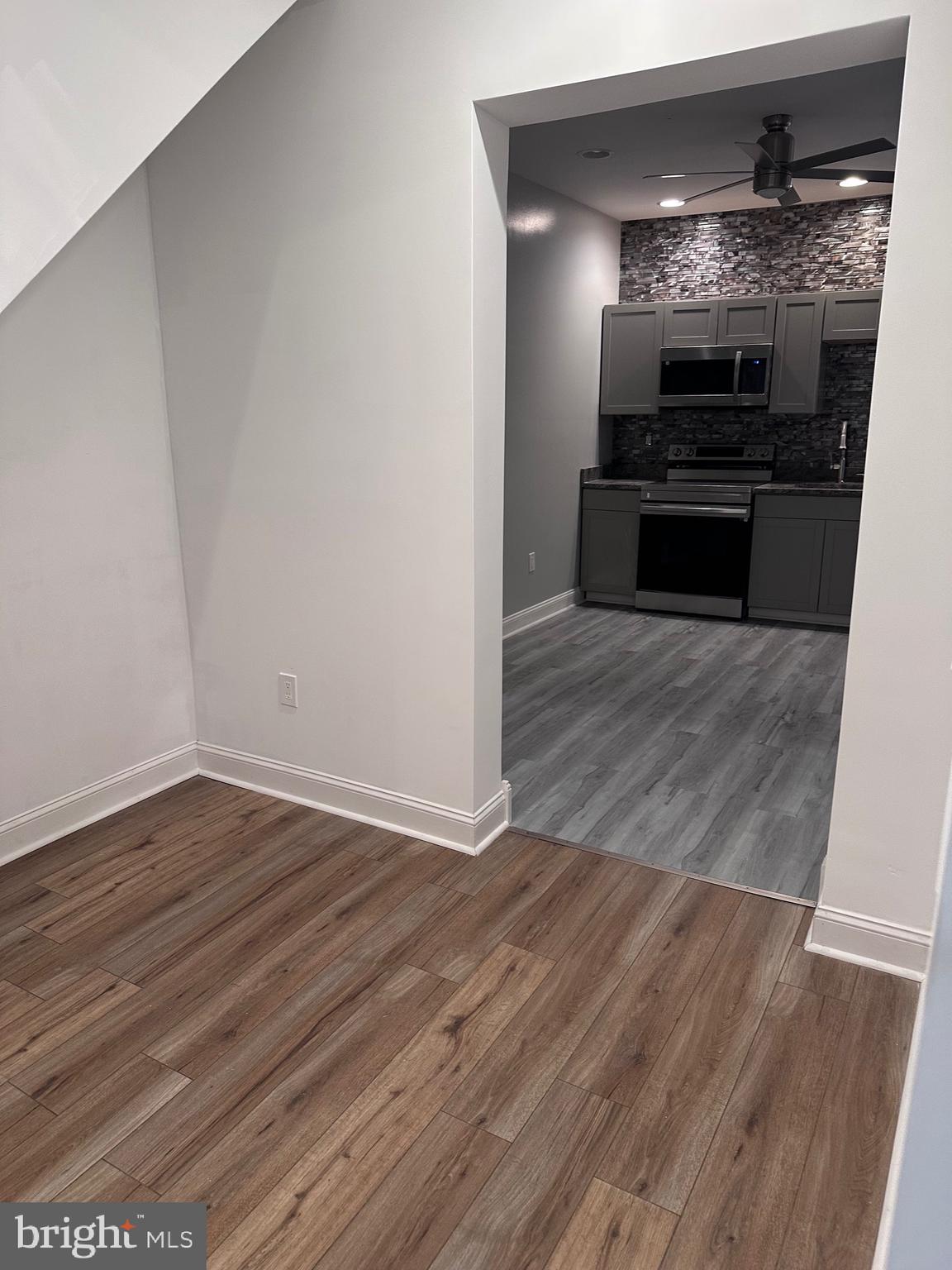 5254 Jefferson Street Philadelphia, PA 19131 - Photo 15 of 30 a view of kitchen and empty room with wooden floor