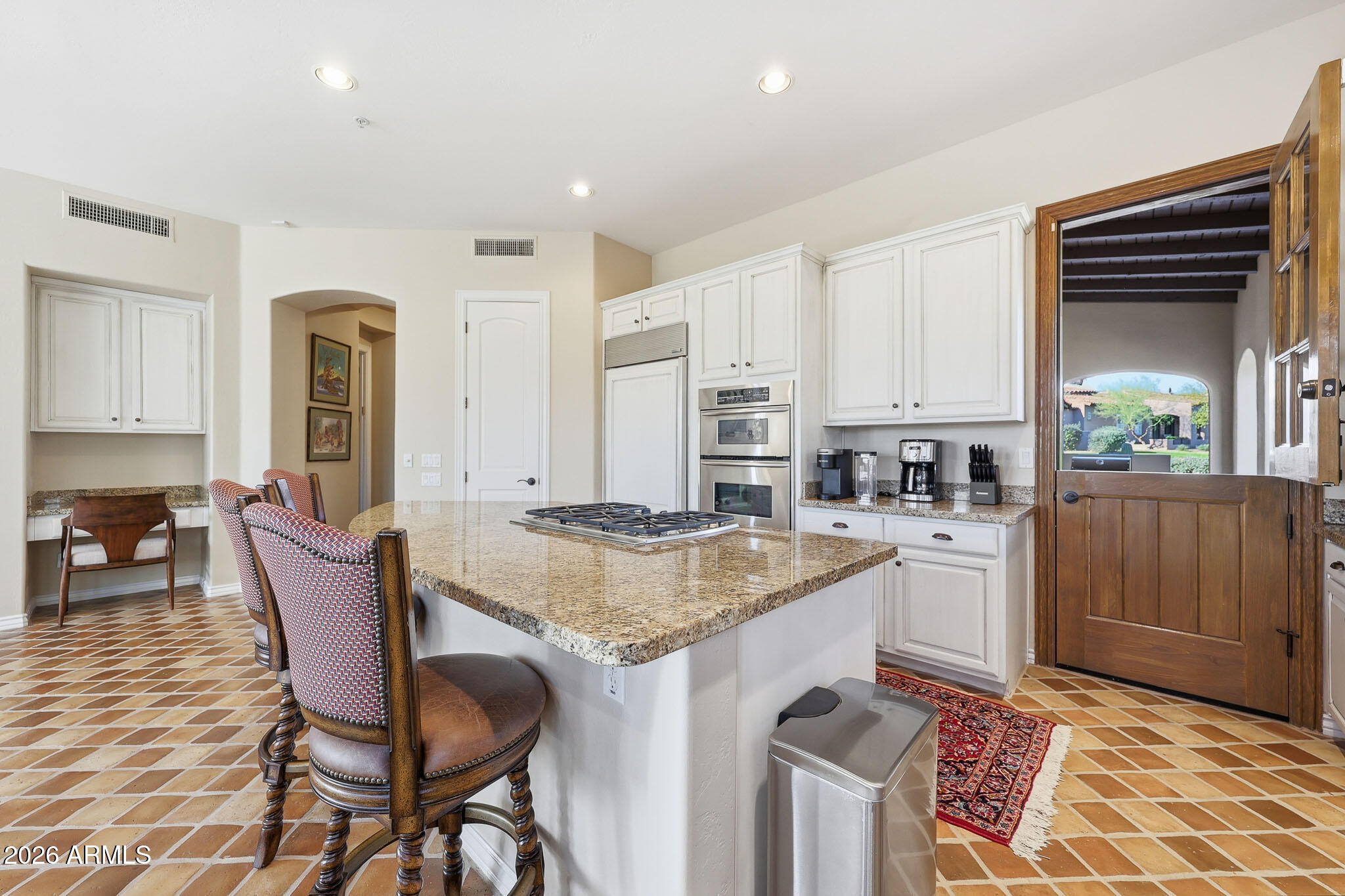 8891 East Mountain Spring Road Scottsdale, AZ 85255 - Photo 15 of 33 a kitchen with stainless steel appliances granite countertop a stove top oven a sink a dining table and chairs with wooden floor