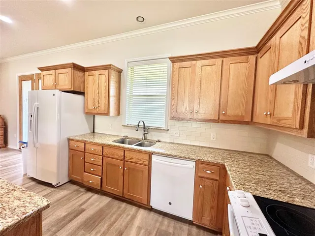 a kitchen with stainless steel appliances granite countertop a refrigerator sink and cabinets