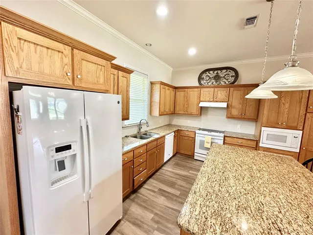 a kitchen with stainless steel appliances granite countertop a refrigerator a stove and a sink