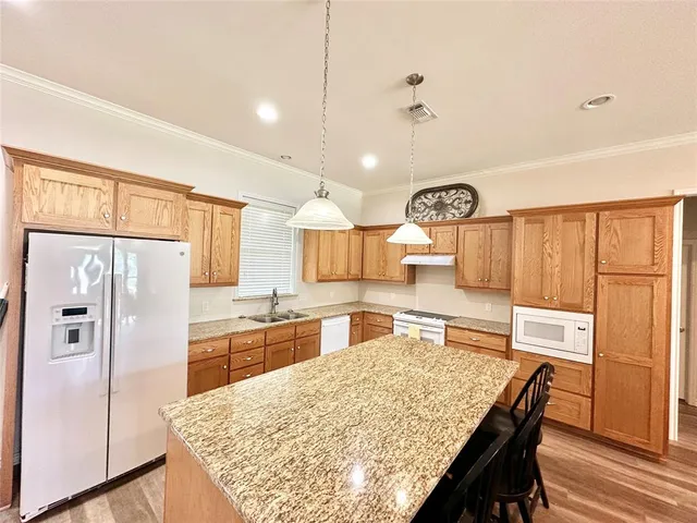 a kitchen with stainless steel appliances granite countertop a refrigerator and a stove top oven