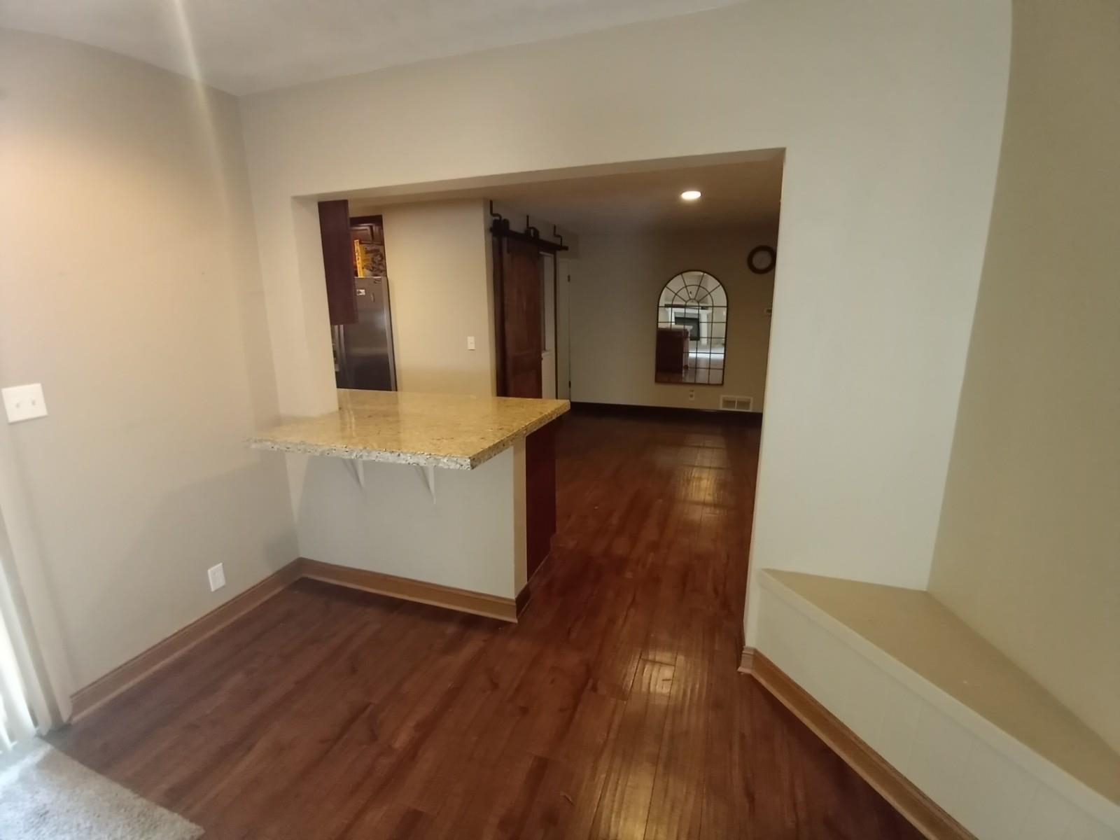 4115 Highcrest Road Rockford, IL 61107 - Photo 4 of 26 an empty room with wooden floor and mirror