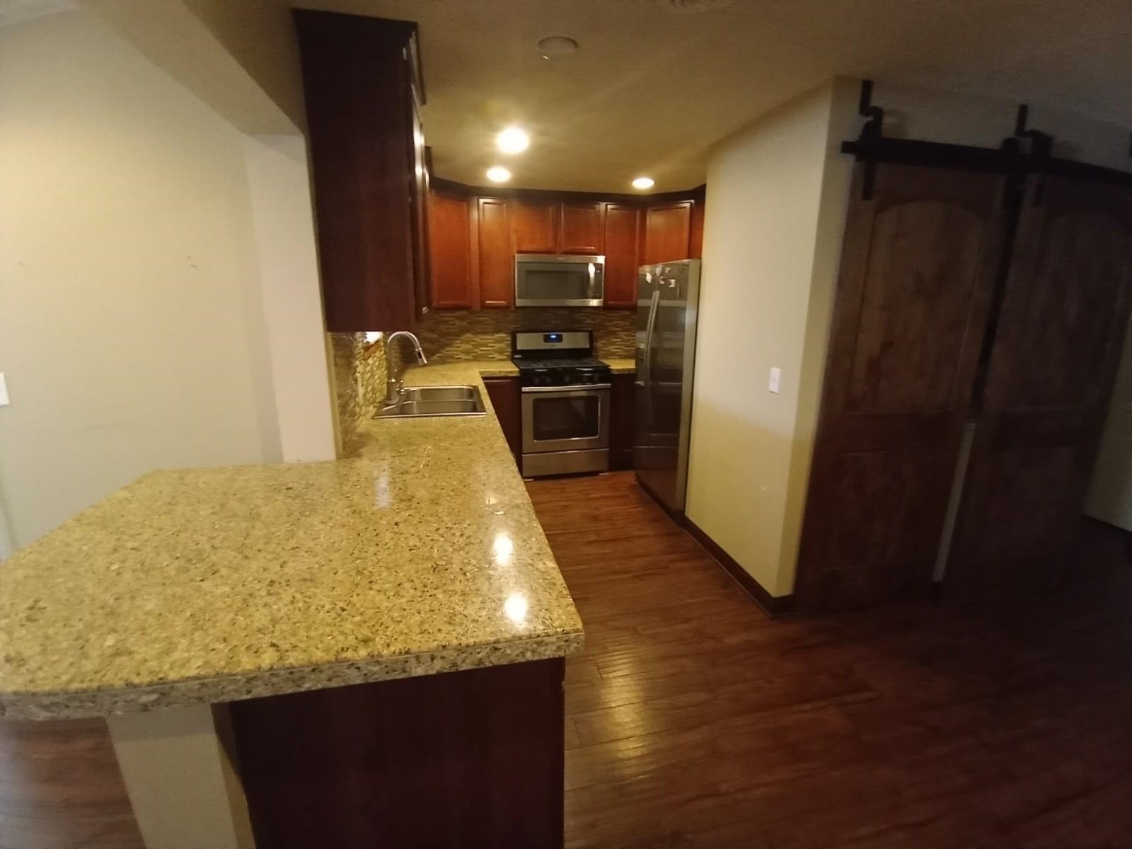 4115 Highcrest Road Rockford, IL 61107 - Photo 5 of 26 a kitchen with kitchen island granite countertop wooden cabinets a sink and a stove