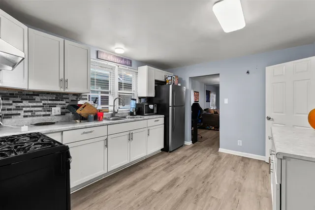 a kitchen with stainless steel appliances granite countertop a refrigerator and a stove top oven