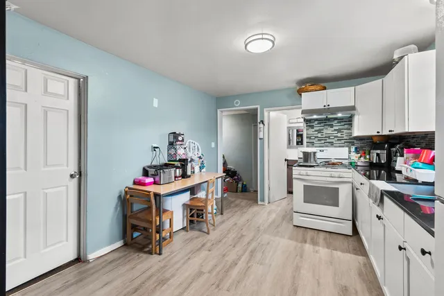 a kitchen with a white stove and white cabinets