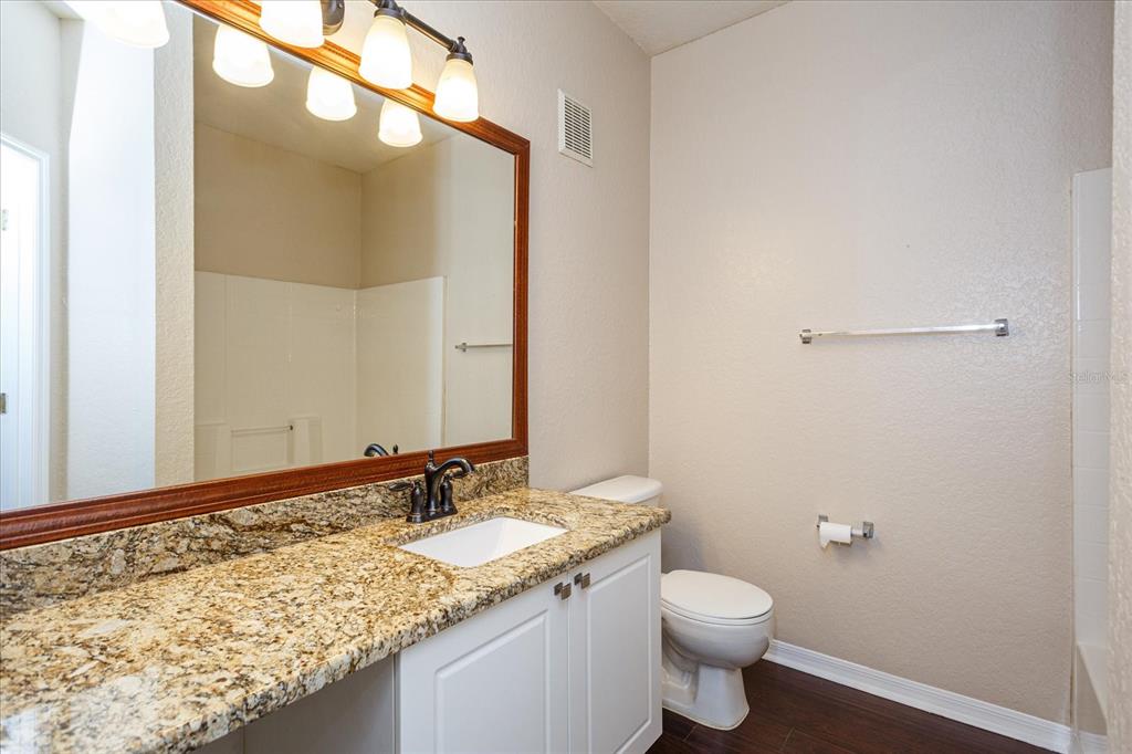 819 Grand Regency Pointe, Unit 203 Altamonte Springs, FL 32714 - Photo 12 of 21 a bathroom with a granite countertop sink toilet and a mirror