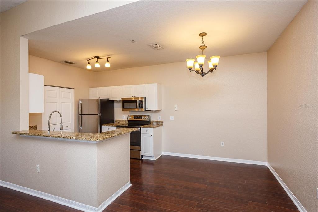 819 Grand Regency Pointe, Unit 203 Altamonte Springs, FL 32714 - Photo 7 of 21 a kitchen with kitchen island granite countertop a sink cabinets and stainless steel appliances