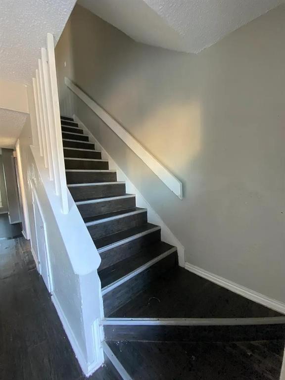 8005 Rothington Road, Unit 51 Dallas, TX 75227 - Photo 4 of 9 Stairway with a textured ceiling and baseboards