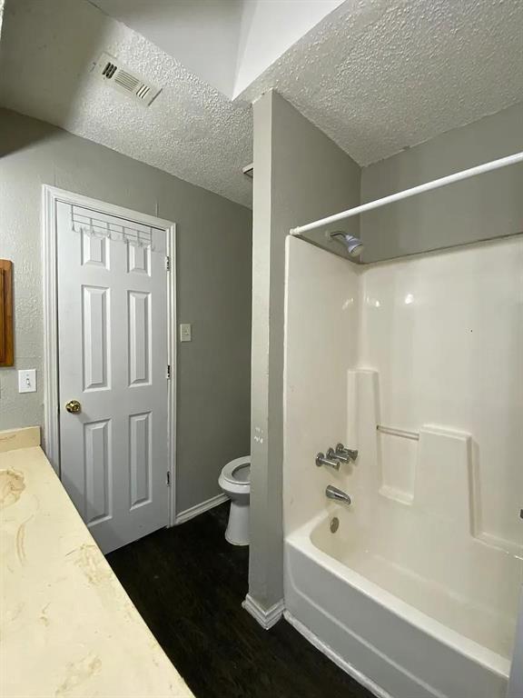 8005 Rothington Road, Unit 51 Dallas, TX 75227 - Photo 5 of 9 Bathroom with bathtub / shower combination, dark wood-style floors, a textured ceiling, and vanity