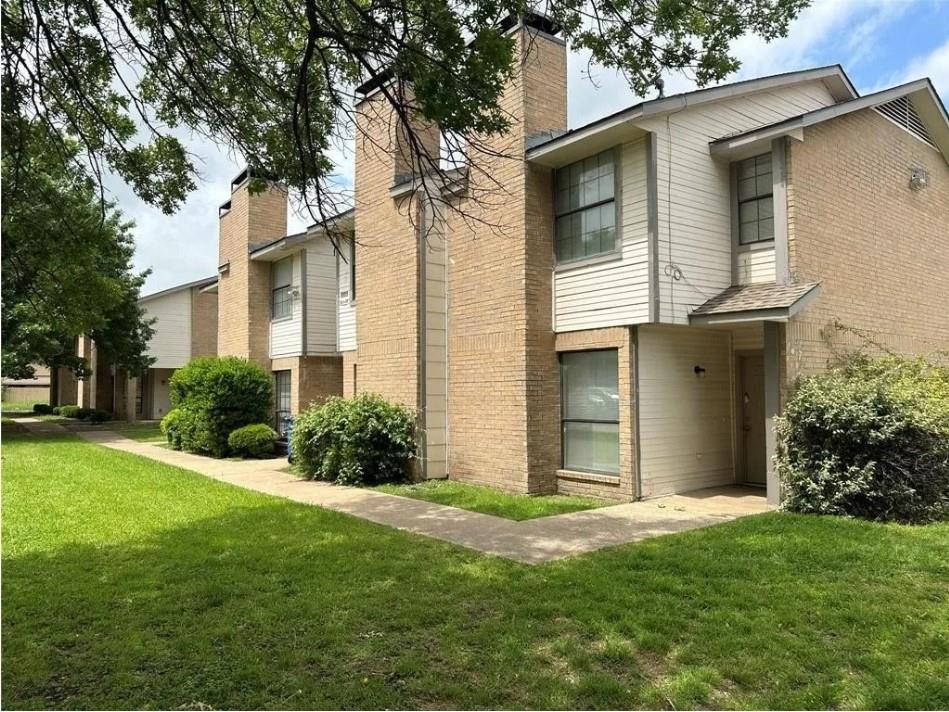 8005 Rothington Road, Unit 51 Dallas, TX 75227 - Photo 9 of 9 View of property exterior featuring a yard, a chimney, and brick siding