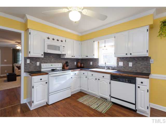4521 Hershey Court Raleigh, NC 27613 - Photo 7 of 24 a kitchen with stainless steel appliances granite countertop a stove a sink and white cabinets