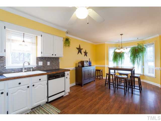 4521 Hershey Court Raleigh, NC 27613 - Photo 8 of 24 a kitchen with granite countertop a table chairs stove and sink