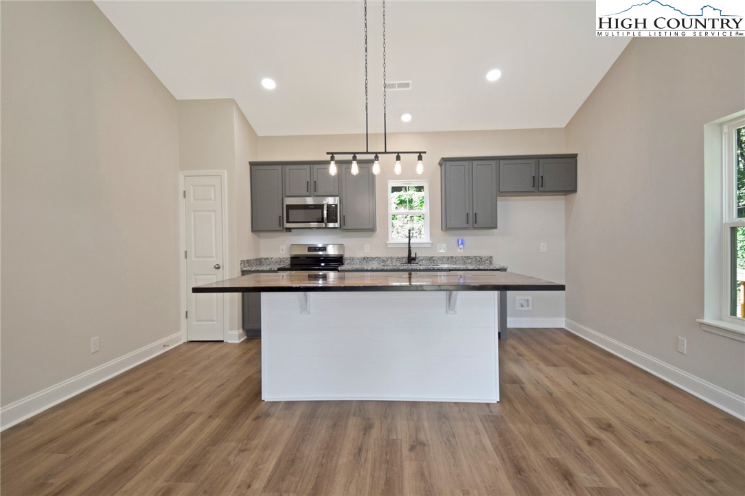 598 Running Deer Trail Boone, NC 28607 - Photo 14 of 49 a kitchen with kitchen island stainless steel appliances a sink cabinets and wooden floor