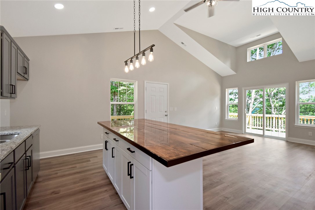 598 Running Deer Trail Boone, NC 28607 - Photo 16 of 49 a kitchen with granite countertop a stove and a wooden floor