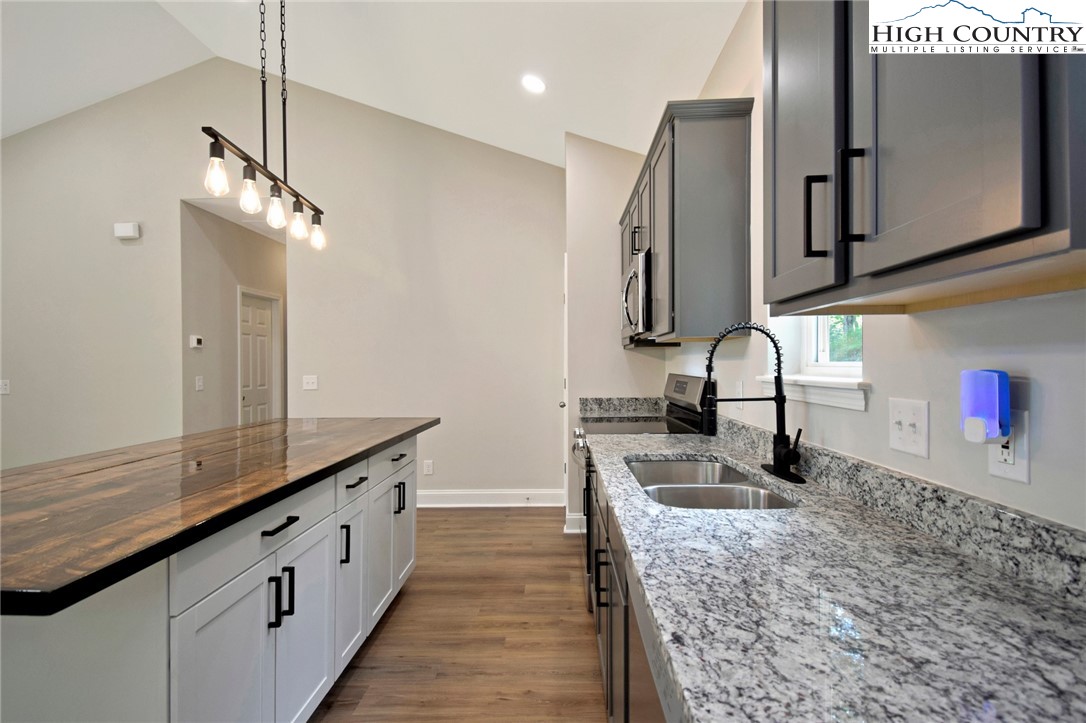 598 Running Deer Trail Boone, NC 28607 - Photo 19 of 49 a kitchen with stainless steel appliances granite countertop a sink refrigerator and microwave