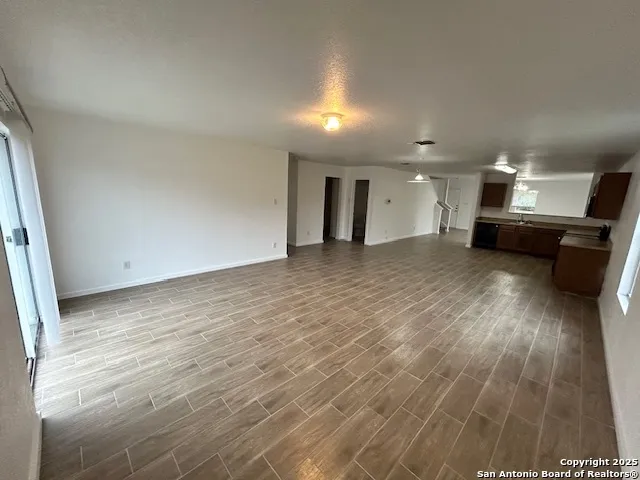 an empty room with wooden floor and furniture