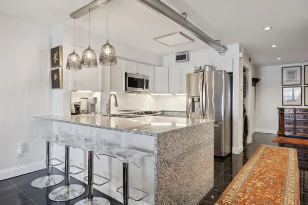 a kitchen with stainless steel appliances granite countertop a sink stove and refrigerator