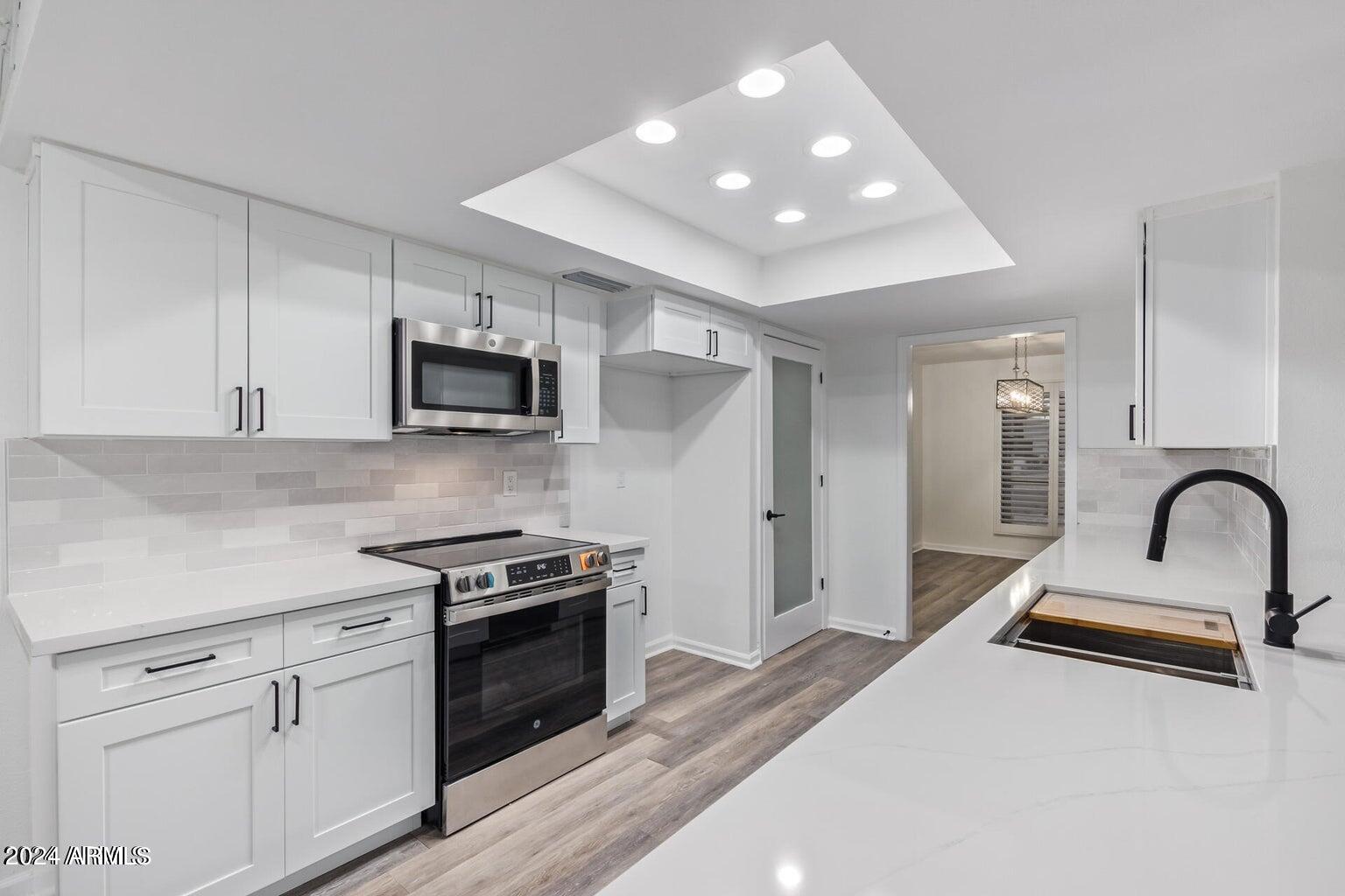 1893 East Bendix Drive Tempe, AZ 85283 - Photo 11 of 45 a kitchen with granite countertop a stove a sink and a microwave