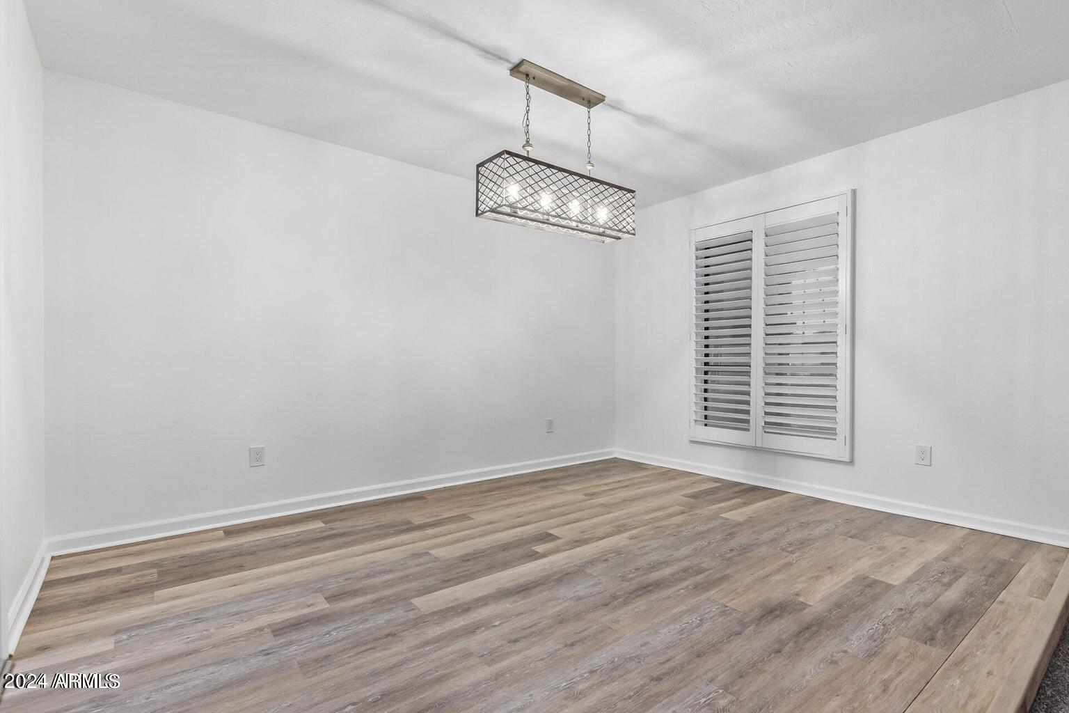 1893 East Bendix Drive Tempe, AZ 85283 - Photo 12 of 45 an empty room with wooden floor a ceiling fan and windows