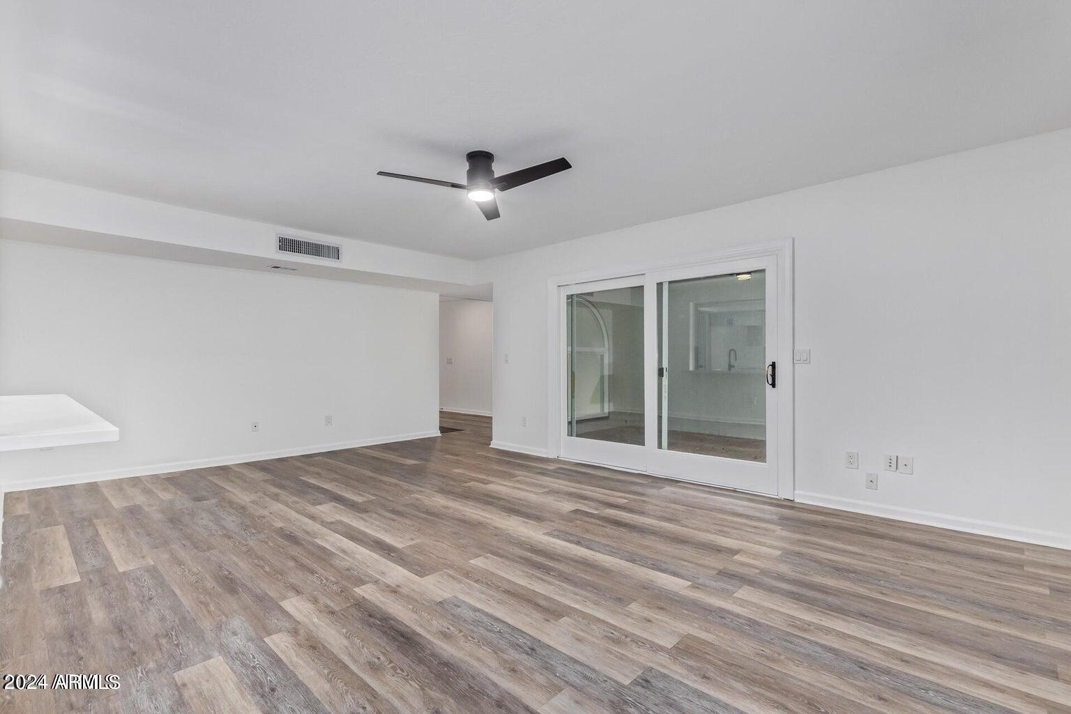 1893 East Bendix Drive Tempe, AZ 85283 - Photo 14 of 45 a view of an empty room with wooden floor and a ceiling fan