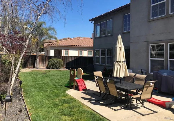 a view of a house with backyard sitting area and furniture