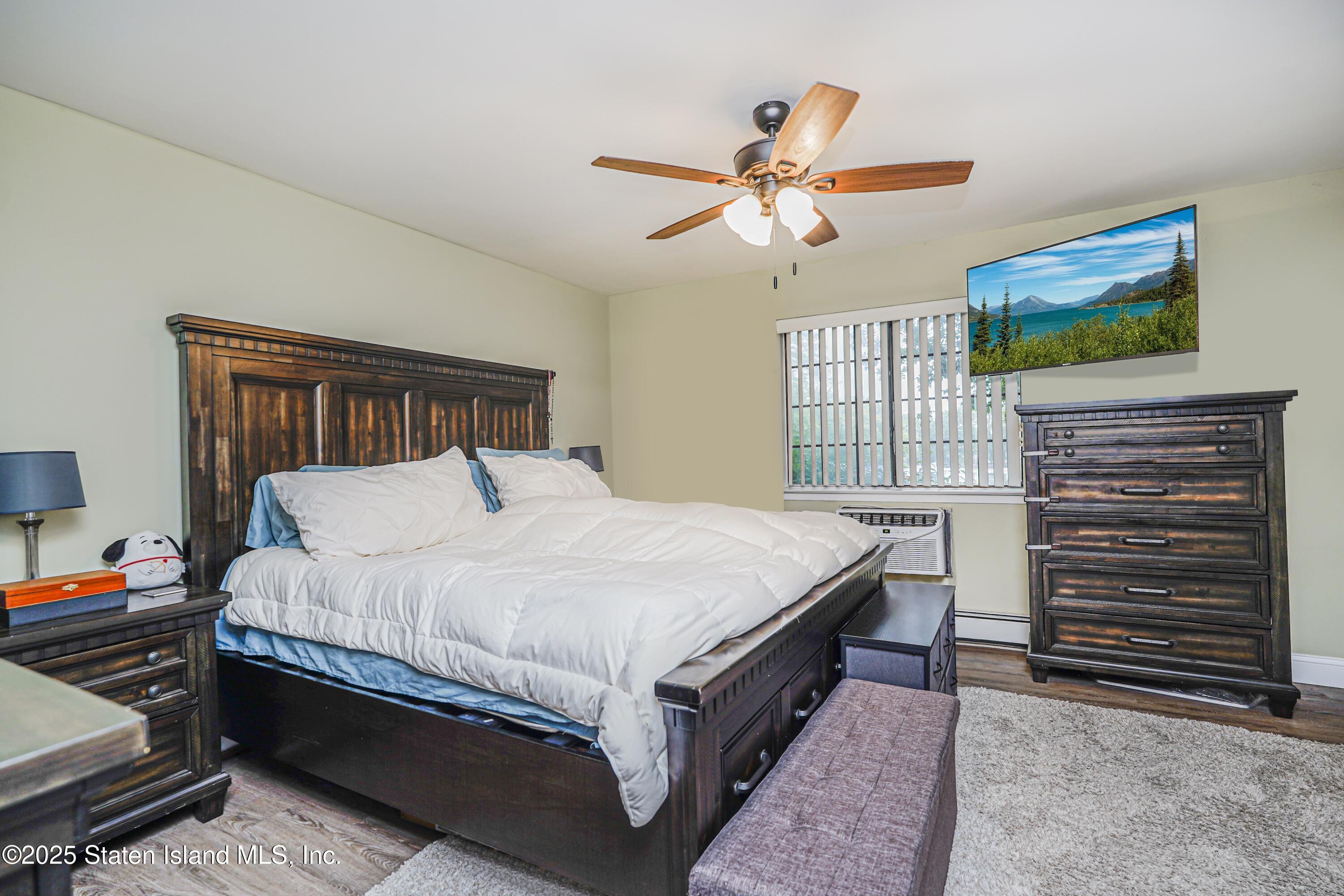 170 Devon Loop, Unit 3 Staten Island, NY 10314 - Photo 12 of 22 a bed sitting in a bedroom next to a window