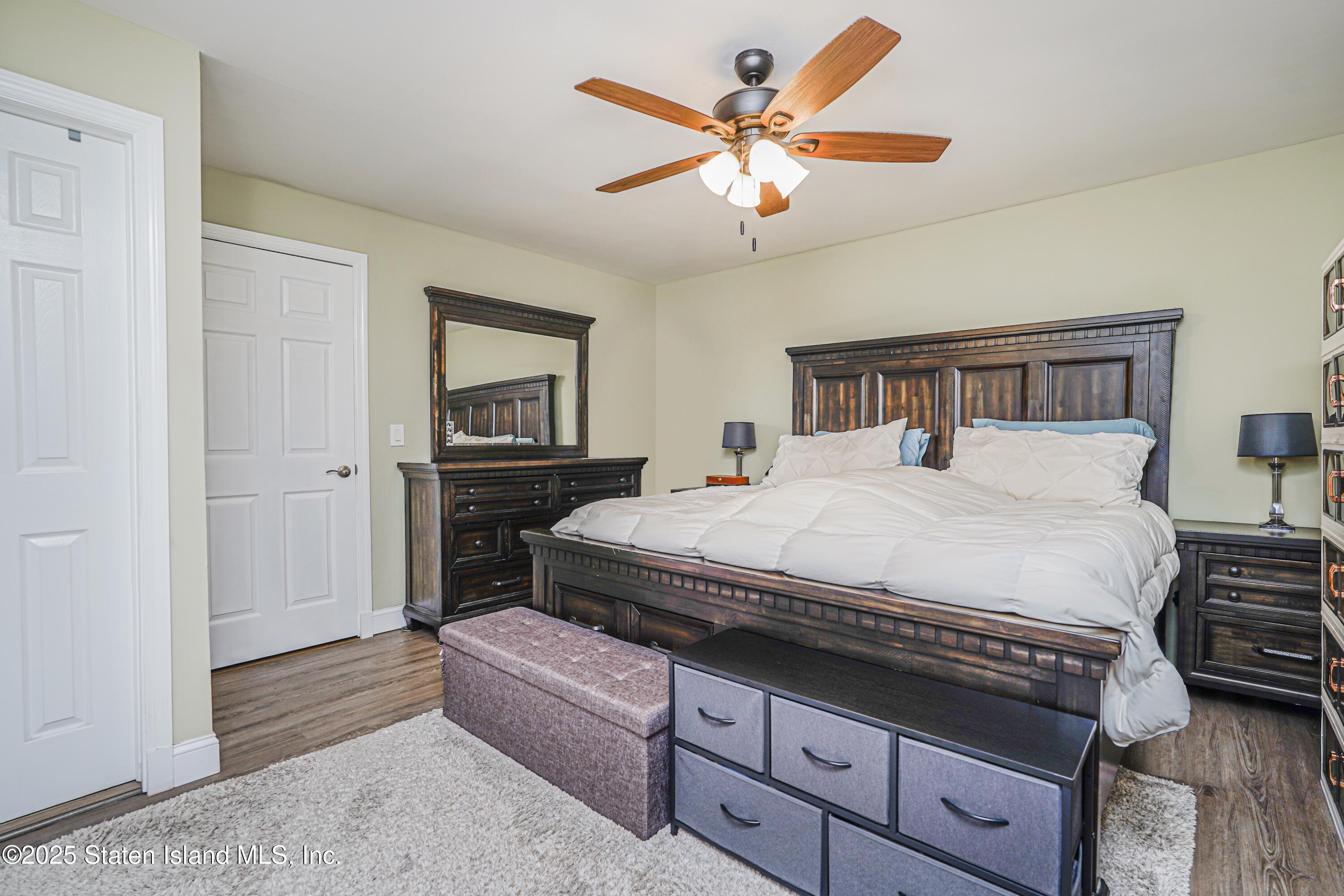 170 Devon Loop, Unit 3 Staten Island, NY 10314 - Photo 13 of 22 a spacious bedroom with a bed a dresser and paintings on the wall