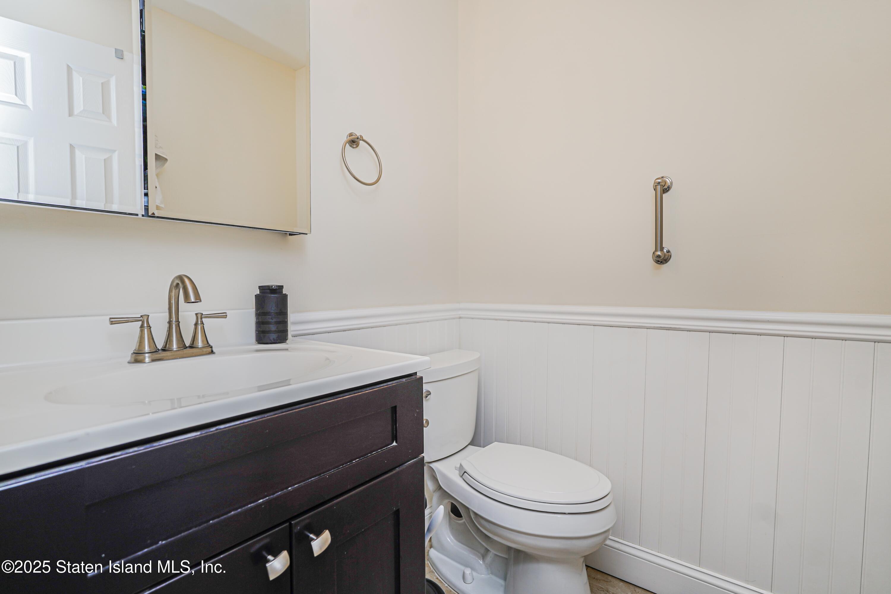 170 Devon Loop, Unit 3 Staten Island, NY 10314 - Photo 14 of 22 a bathroom with a sink a toilet and mirror