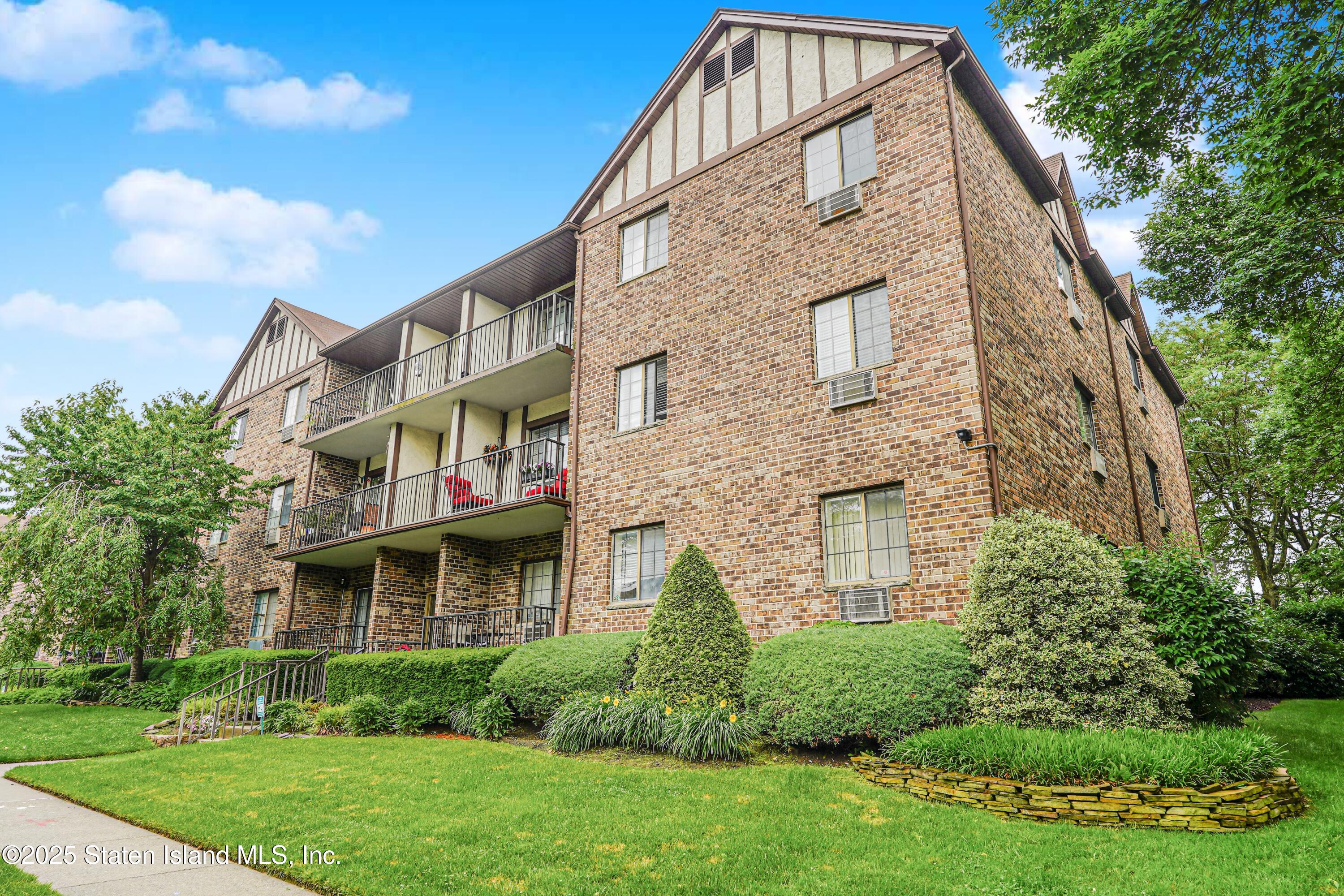 170 Devon Loop, Unit 3 Staten Island, NY 10314 - Photo 2 of 22 a view of a brick building with a yard
