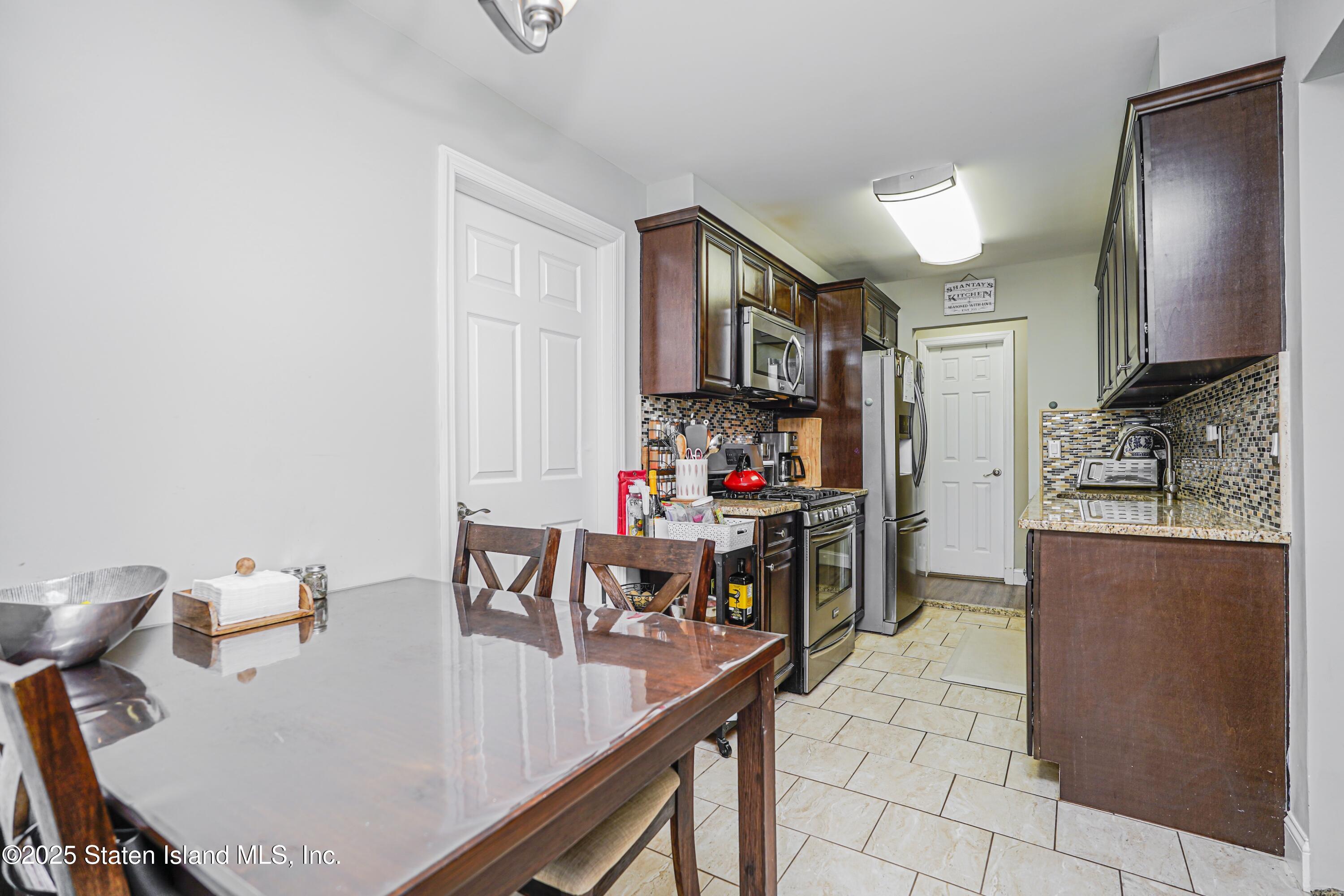 170 Devon Loop, Unit 3 Staten Island, NY 10314 - Photo 9 of 22 a dining room with furniture and a flat screen tv