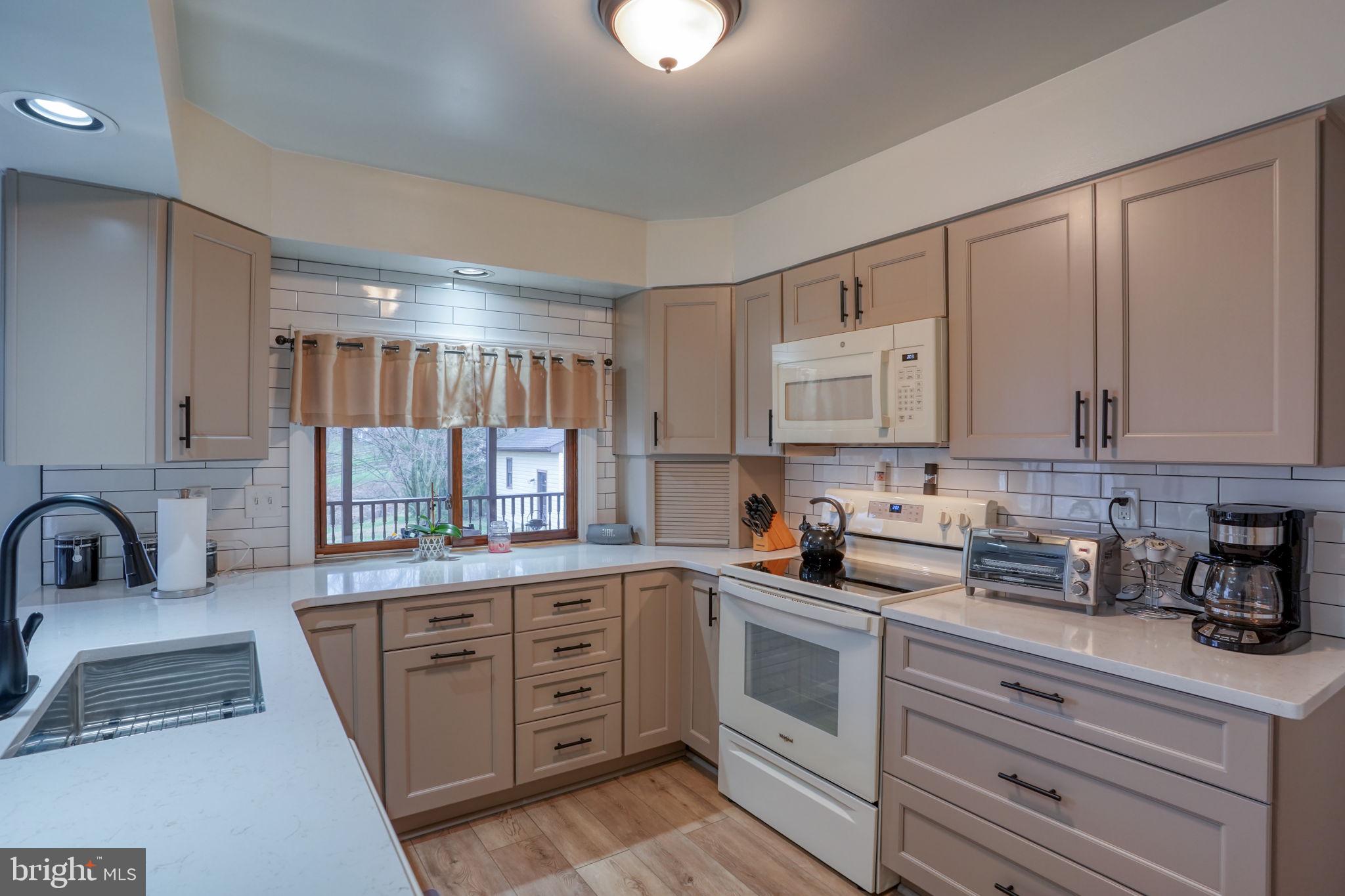 3850 Naamans Creek Road Upper Chichester, PA 19061 - Photo 13 of 53 a kitchen with cabinets appliances a sink and a counter top space