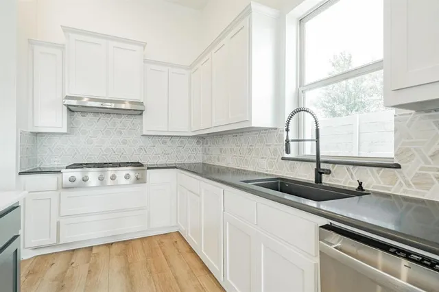 a kitchen with granite countertop white cabinets and white appliances