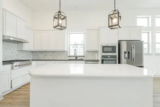 a kitchen with granite countertop a sink and a stove