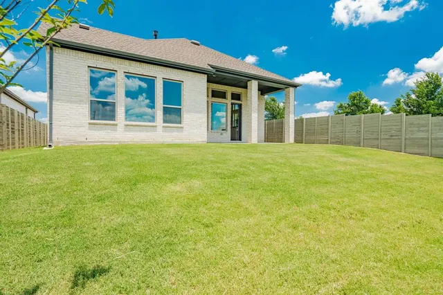 a view of a backyard with brick wall and a chair