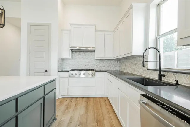 a kitchen with a sink stove and cabinets