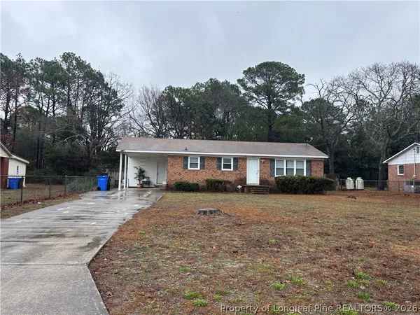 a view of a house with a yard and large tree