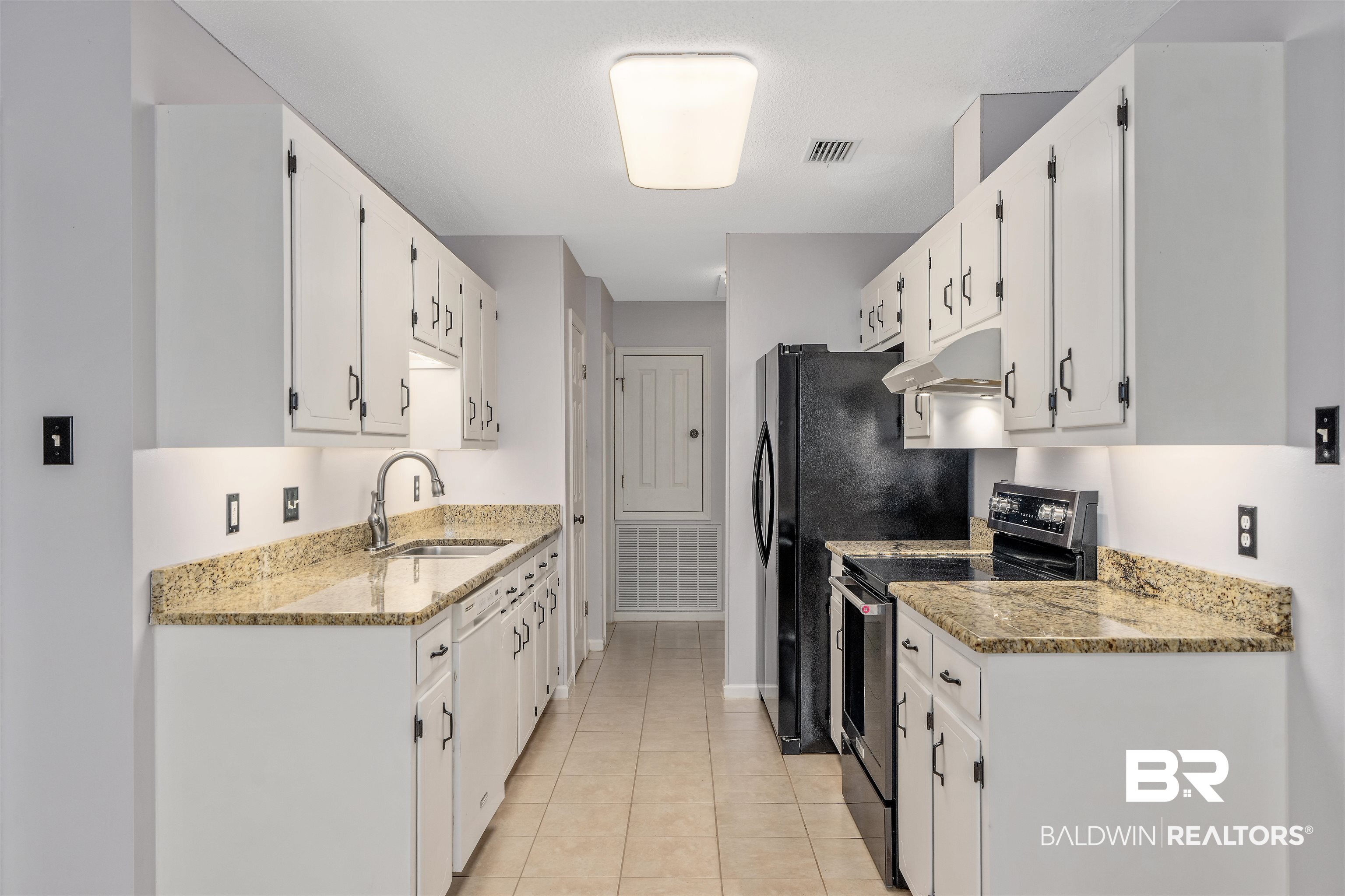 25779 Austin Road Daphne, AL 36526 - Photo 19 of 30 Kitchen featuring stainless steel electric range oven, a sink, under cabinet range hood, white cabinets, and light tile patterned floors