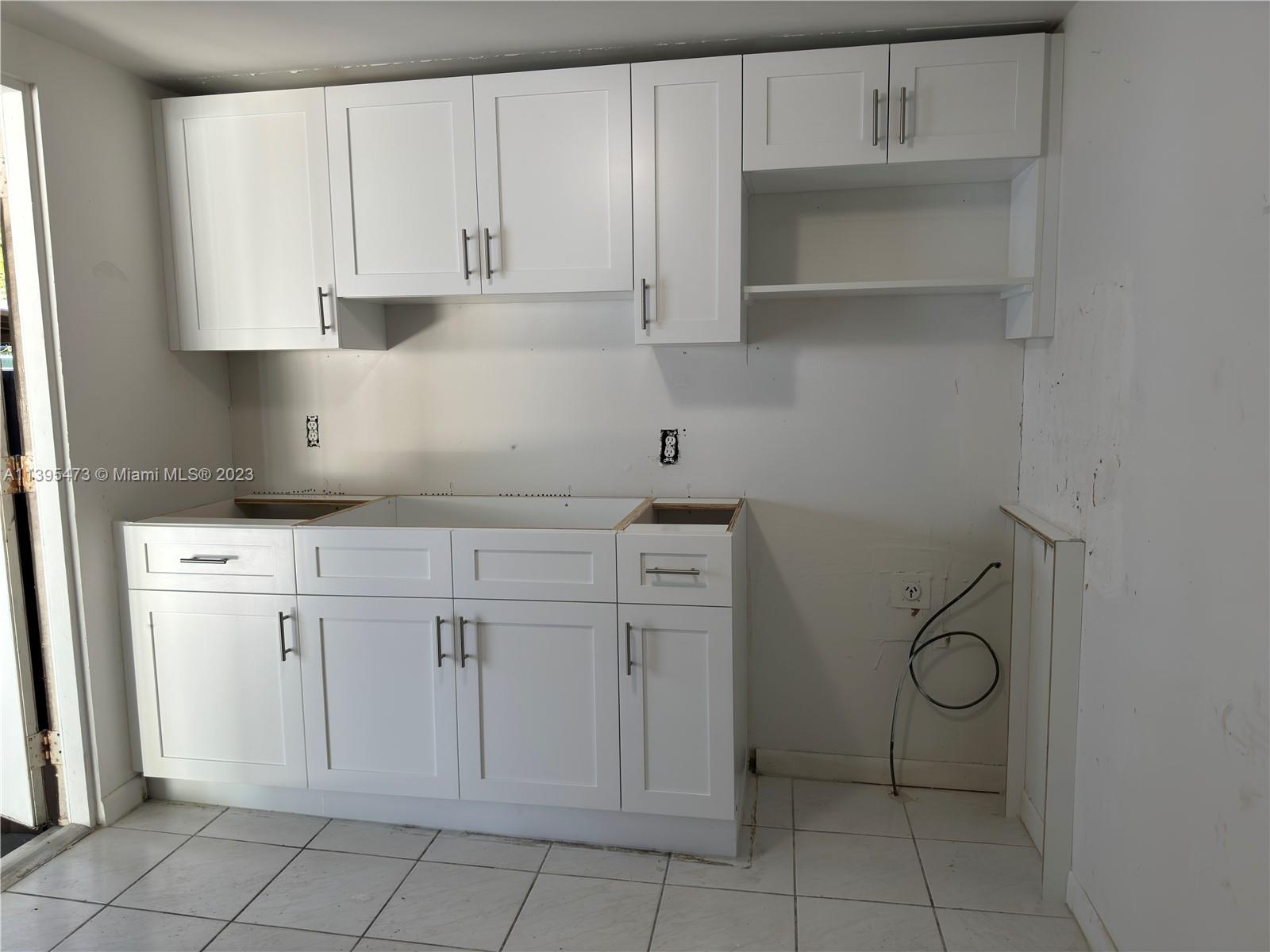 276 East 12th Street Hialeah, FL 33010 - Photo 10 of 27 a kitchen with white cabinets