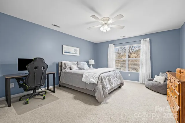a bedroom with a bed window and a ceiling fan