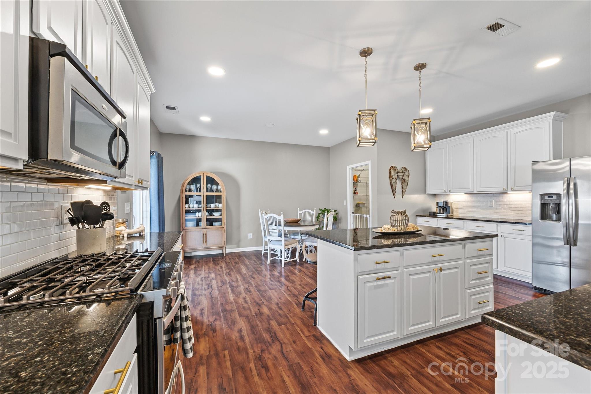 422 Garden Grove Road Fort Mill, SC 29708 - Photo 6 of 39 a kitchen with stainless steel appliances a stove a sink dishwasher and cabinets with wooden floor
