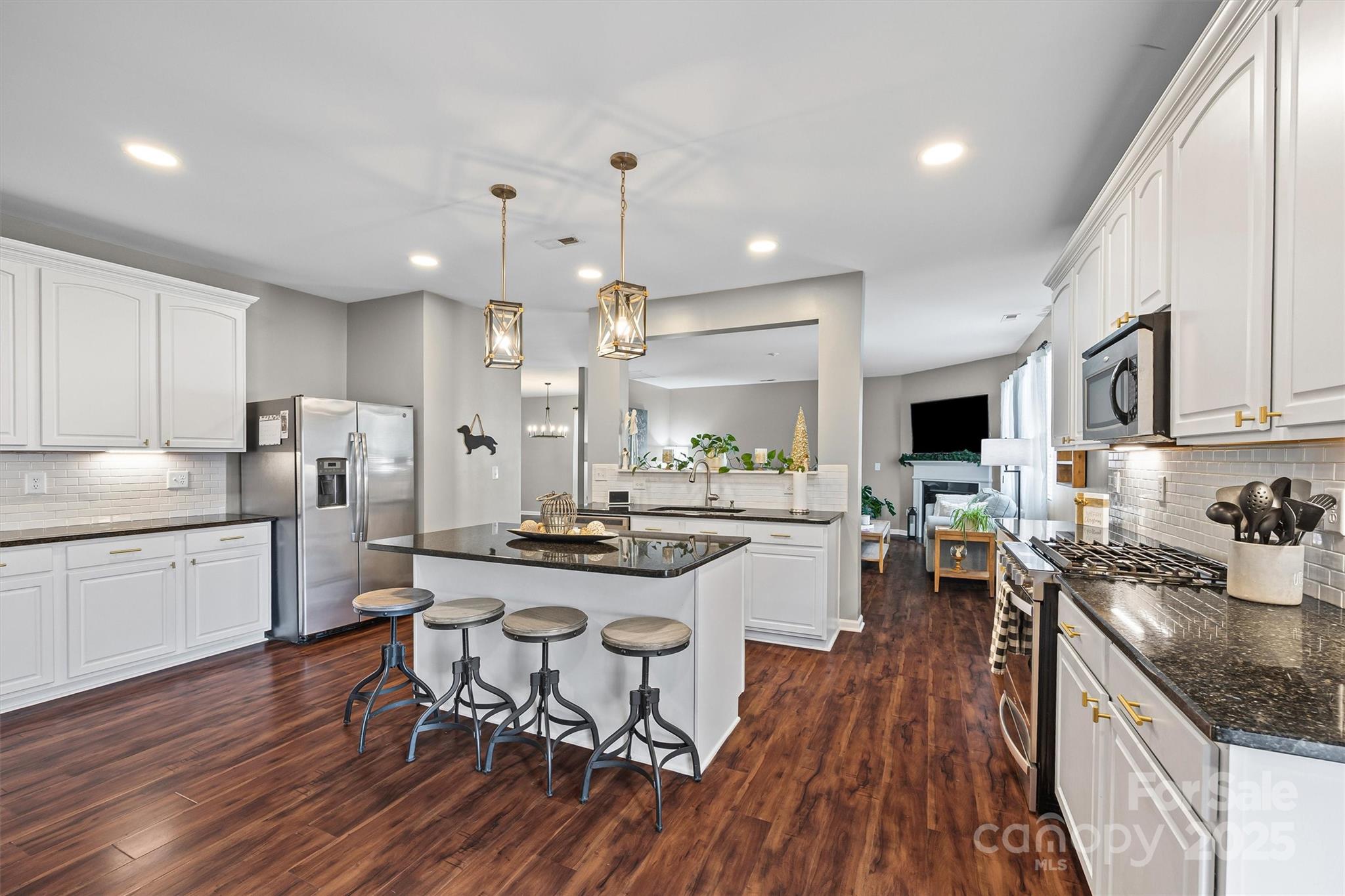 422 Garden Grove Road Fort Mill, SC 29708 - Photo 7 of 39 a kitchen with a table chairs stove a sink dishwasher and cabinets with wooden floor