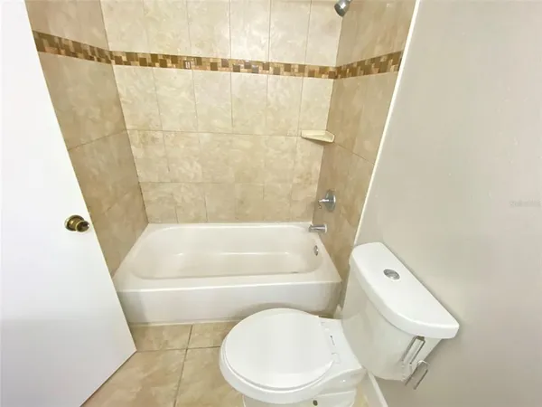 a white toilet sitting next to a bath tub