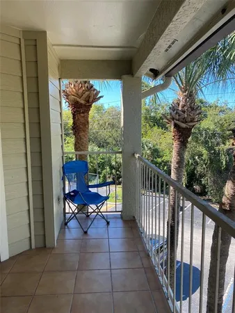 a view of a porch with furniture and floor to ceiling window