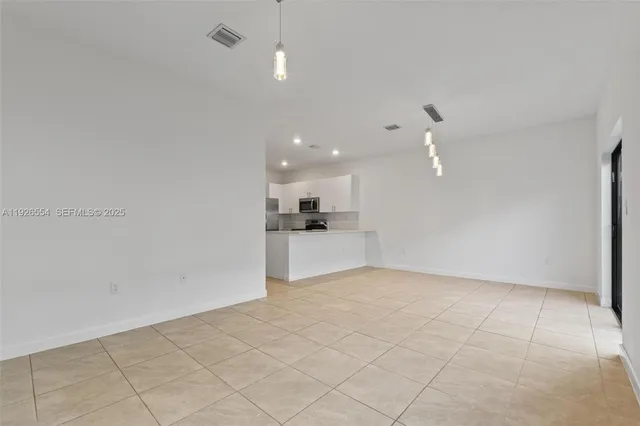 a view of a kitchen with a sink and a refrigerator