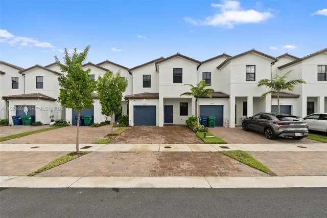 a view of white house with a yard and large windows