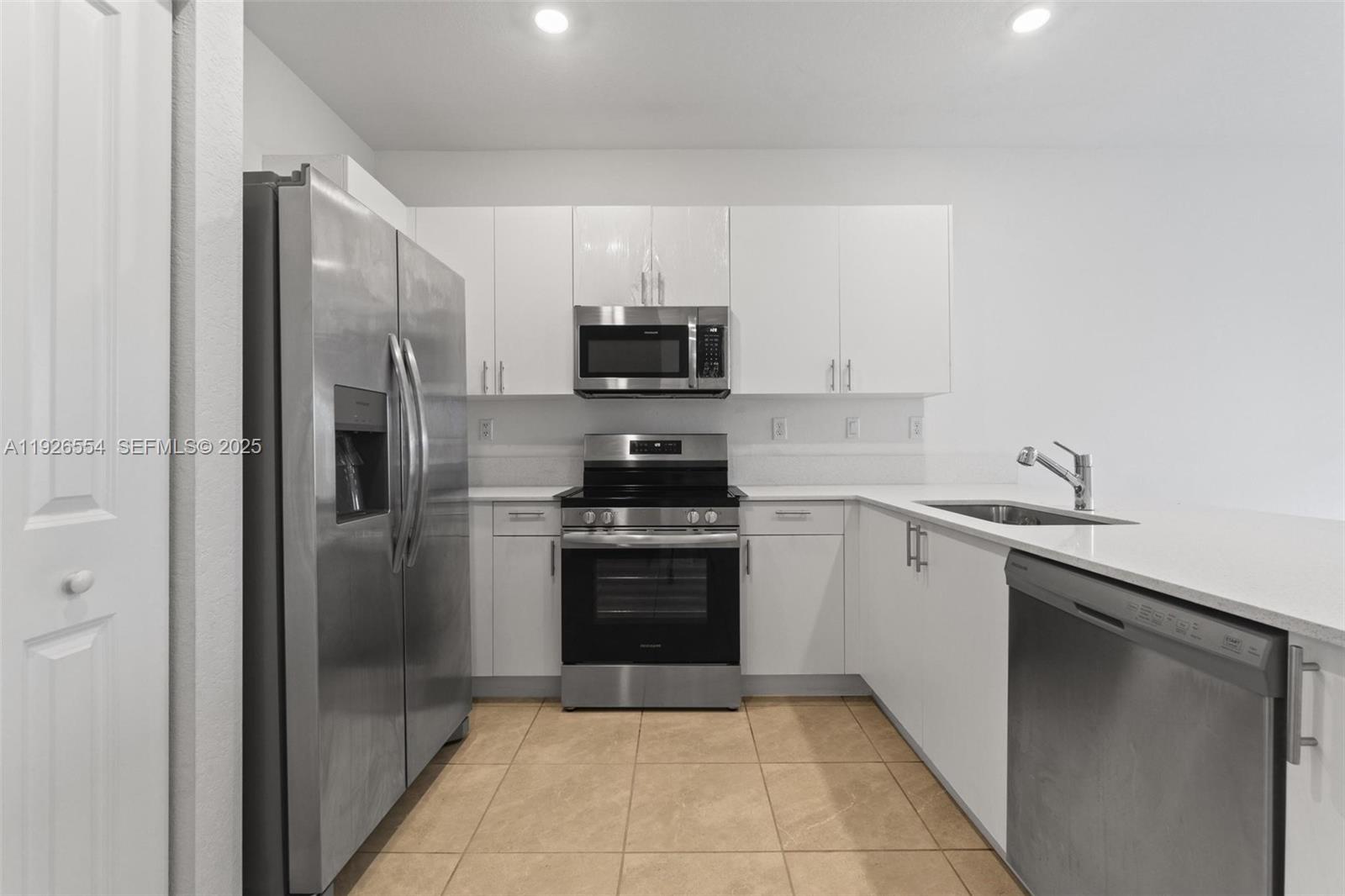 23016 Southwest 129th Court Miami, FL 33177 - Photo 9 of 39 a kitchen with a sink and a stove top oven